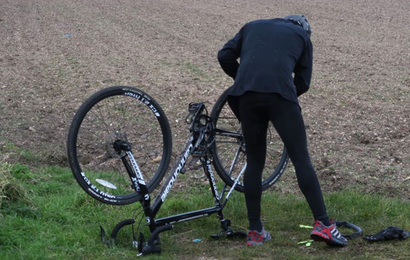 Ciclista revisando ruedas de su bicicleta.